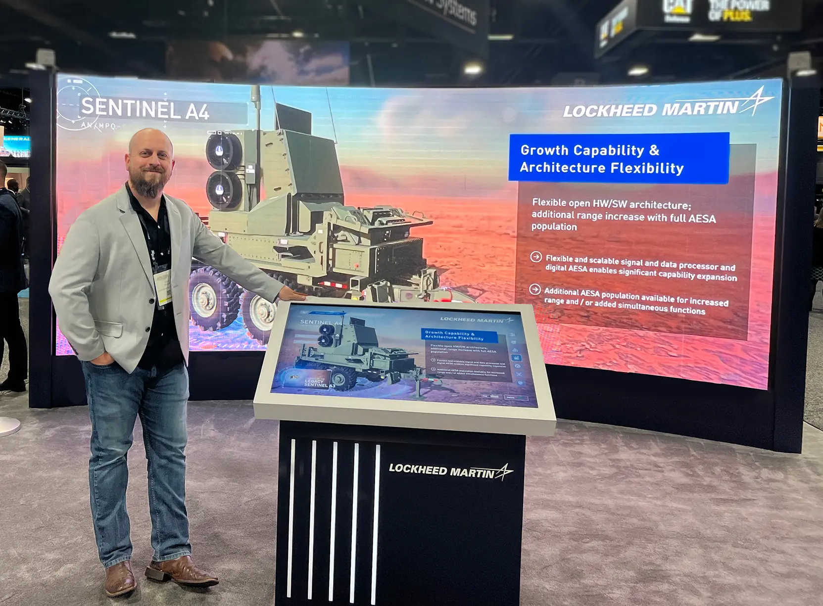 Cole Wiser beside the Lockheed Martin Sentinel A4 experience